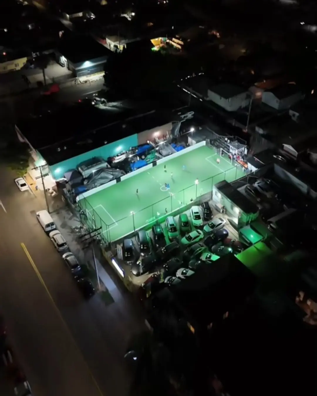 Aerial view of La Canchita lit up at night in Barrio Logan, San Diego
