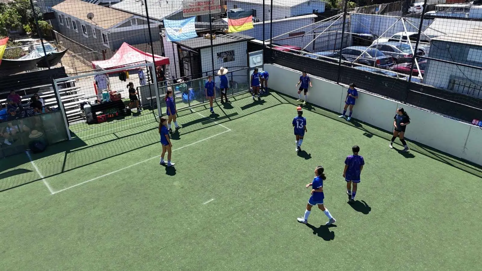 Youth players battle for the ball on the walled field at EVO St La Canchita in San Diego